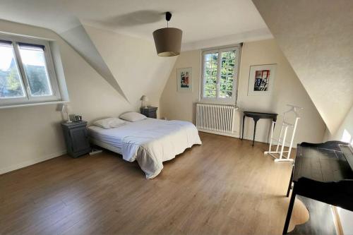 Habitación blanca con cama y piano en Grande maison en bord de mer, en Concarneau