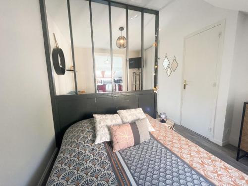 um quarto com uma cama e um espelho grande em Le 12 Bis - COSY em Cherbourg en Cotentin