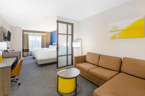 Habitación de hotel con sofá y cama en Comfort Suites, en Pecos