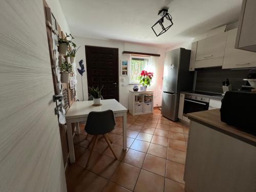 a kitchen with a small table and a refrigerator at The Comfy Apartment in Ponte Capriasca
