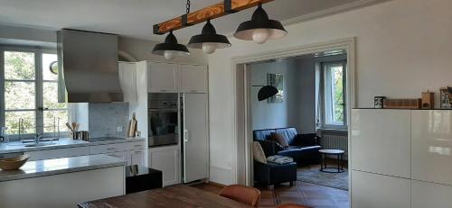 cocina con armarios blancos y sala de estar. en Einzigartiges Appartement im Höfli11 mit 3 Schlafzimmer en Solothurn