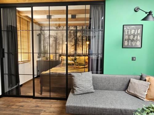 a living room with a couch and a glass wall at Cracovia Luxury Bright Apartment Great Location Sauna in Krakow