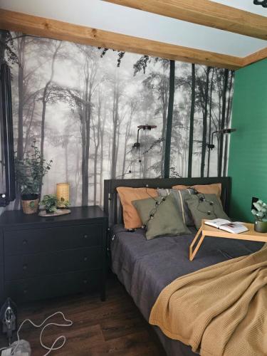 a bedroom with a bed with a forest mural at Cracovia Luxury Bright Apartment Great Location Sauna in Krakow