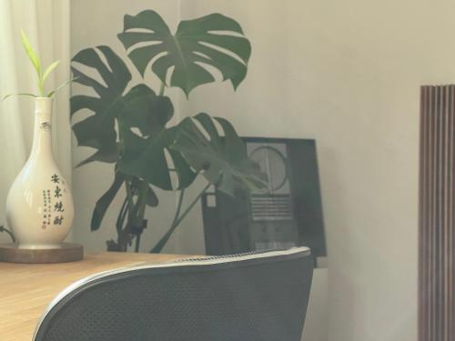 a desk with a chair and a vase and a plant at The Comfy Apartment in Ponte Capriasca