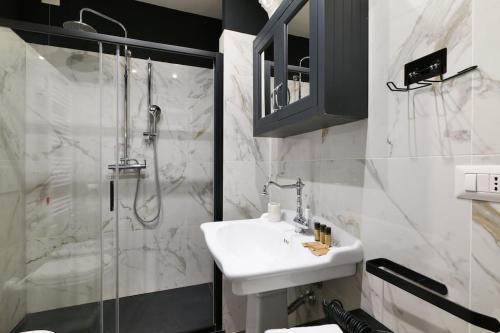 ein weißes Bad mit einem Waschbecken und einer Dusche in der Unterkunft St James Suite in Mailand