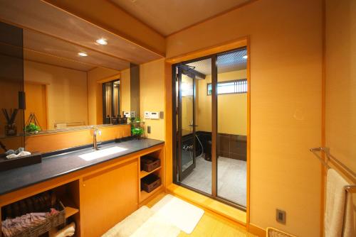 y baño con lavabo y ducha acristalada. en Kasuitei Ooya en Fujikawaguchiko