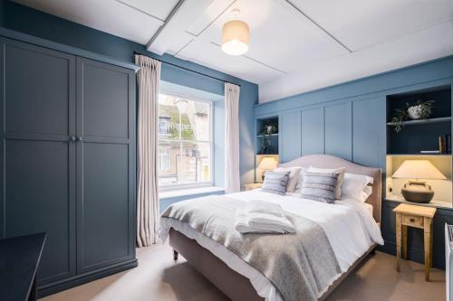 a blue bedroom with a bed and a window at Great Escapes Oundle Flat 3 in Oundle
