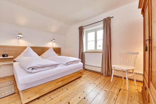 - une chambre avec un lit, une chaise et une fenêtre dans l'établissement Alpenwelt III, à Garmisch-Partenkirchen