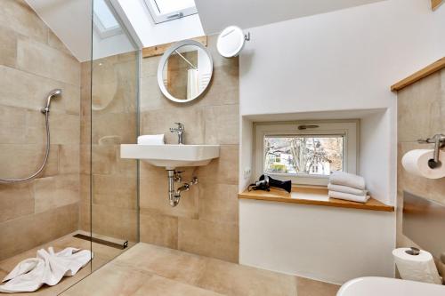 La salle de bains est pourvue d'une douche, d'un lavabo et d'un miroir. dans l'établissement Alpenwelt III, à Garmisch-Partenkirchen