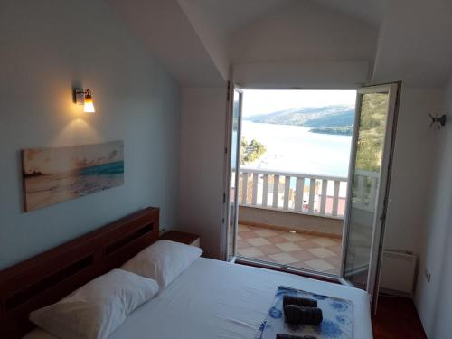 a bedroom with a bed and a view of the water at Apartments Silvije in Marina