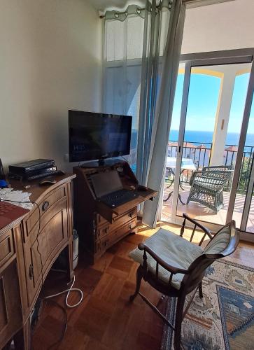 a room with a desk with a computer and a balcony at Apartment Palma Madeira wandern und tauchen in Caniço