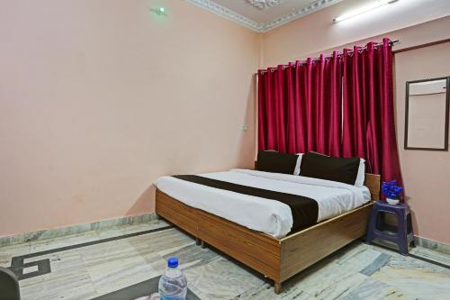 a bedroom with a bed with a red curtain at OYO Hotel Trishakti Homestay in Lucknow