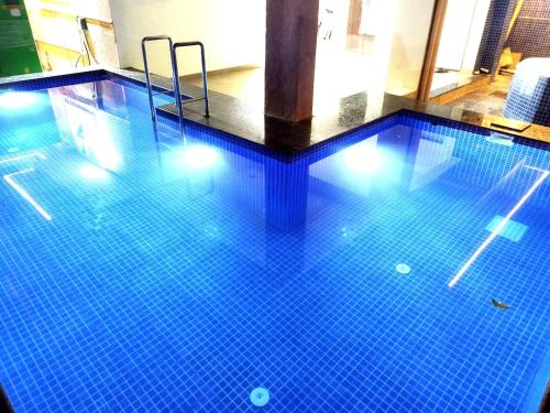 una piscina con azulejos azules en el suelo en Hotel comfort inn en Calangute