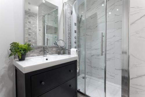 a bathroom with a sink and a shower at Flatzy - 3 Bedroom Apartment in Heart of City Centre in Liverpool