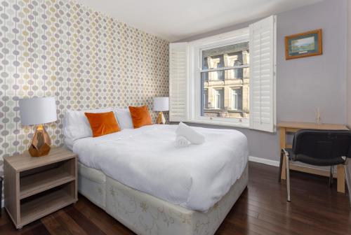 a bedroom with a bed and a desk and a window at Flatzy - 3 Bedroom Apartment in Heart of City Centre in Liverpool
