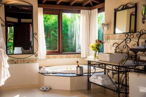 a bathroom with a tub and a sink and a window at Maua Brasil Hotelaria in Visconde De Maua