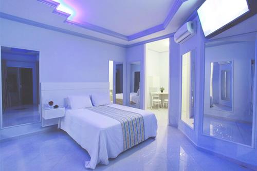 ein weißes Schlafzimmer mit einem weißen Bett und einem Fenster in der Unterkunft Motel Haraam in Araraquara