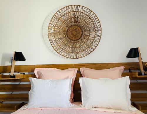 a bedroom with a bed with pink and white pillows at Le Mas de Mirabel in Mirabel-aux-Baronnies