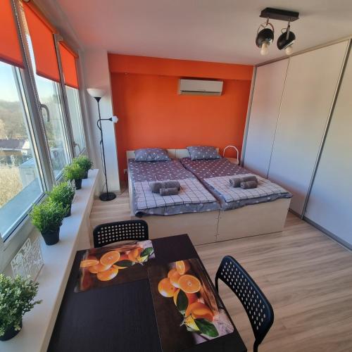una camera con letto, tavolo e sedie di Orange Apartment Kraków a Cracovia