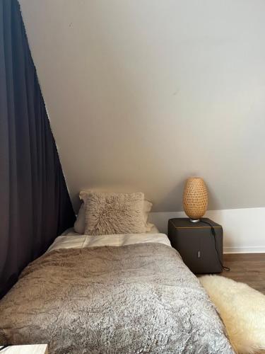 a bedroom with a bed and a table with a lamp at Sportalm Gipfelglück in Lüdenscheid