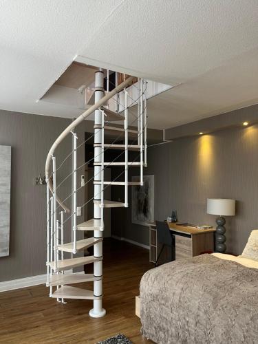 a white spiral staircase in a bedroom with a bed at Sportalm Gipfelglück in Lüdenscheid