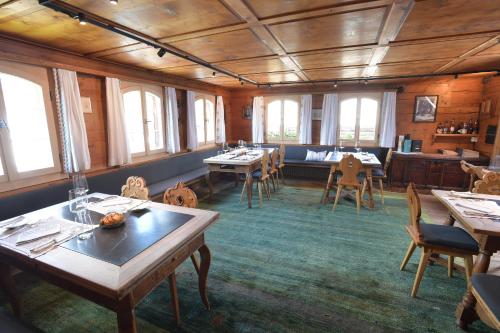 a dining room with tables and chairs and windows at Casa Fausta Capaul in Brigels