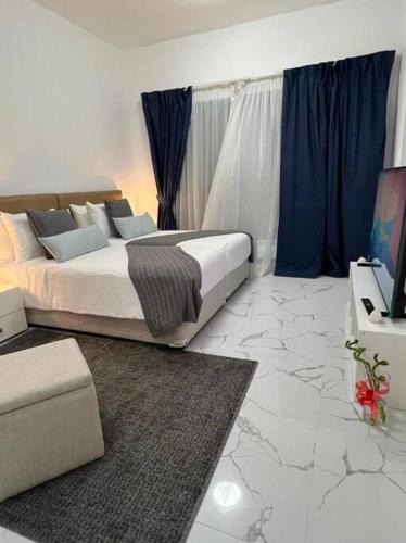 1 dormitorio con 1 cama y TV. en Private room available in Arjan., en Dubái