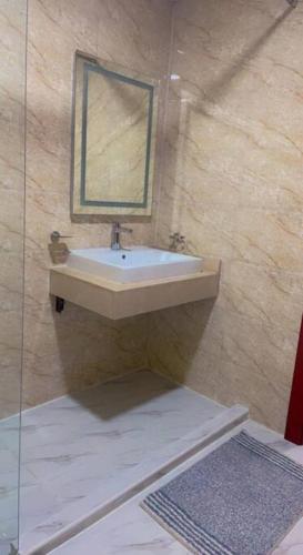 a bathroom with a sink and a mirror at Private room available in Arjan. in Dubai