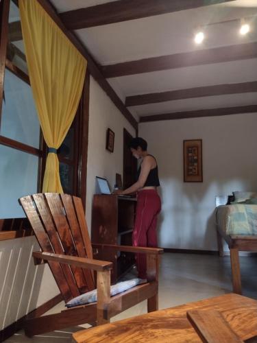 a woman standing in a room with a laptop at Posada del Cerro in El Remate