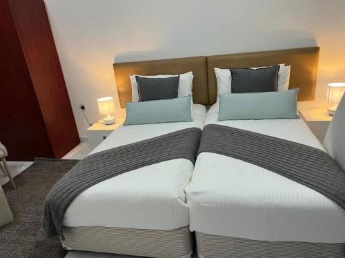 two beds in a hotel room with two pillows at Private room available in Arjan. in Dubai