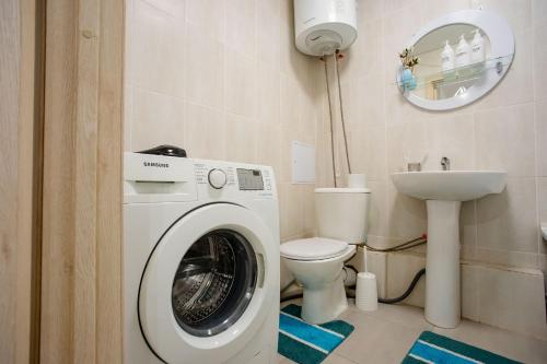 ein Badezimmer mit einer Waschmaschine und einem WC in der Unterkunft 1-ком Тобол Арена, Костанай Плаза, Allur auto, НИШ БЕРЕКЕ in Qostanai