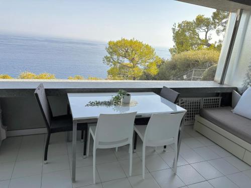 a table and chairs on a balcony with a view of the ocean at RIVIERA Appart'hôtel Panoramique in Cap d'Ail
