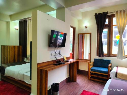 een slaapkamer met een bed, een tv en een stoel bij Aurora Gangtok in Gangtok