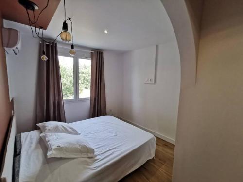 un lit blanc dans une chambre avec une fenêtre dans l'établissement Terrazzo chambres climatisation parking proche remparts, à Avignon