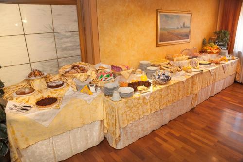 a long table filled with food and plates of food at Hotel La Ruota in Pianfei