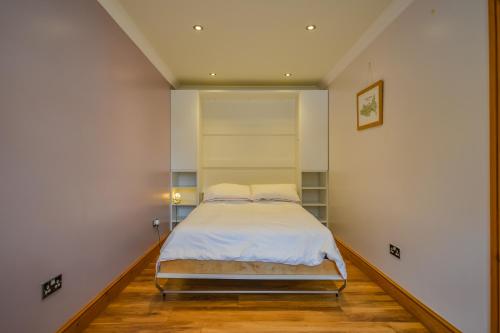 a bedroom with a bed in the corner of a room at Cosy Cabin Perfect To Explore in Garnant