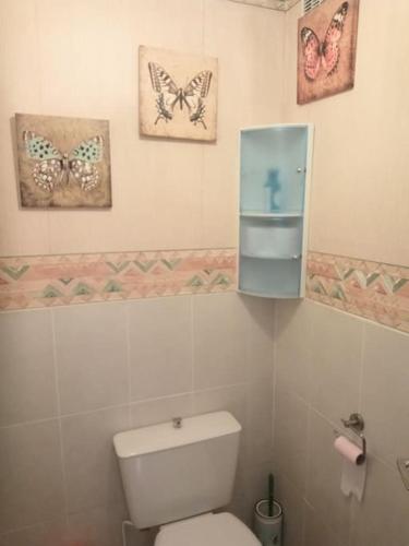 La salle de bains est pourvue de toilettes et de papillons sur le mur. dans l'établissement Cottage by the Chateau with pool in National Parc, à Les Salles-Lavauguyon