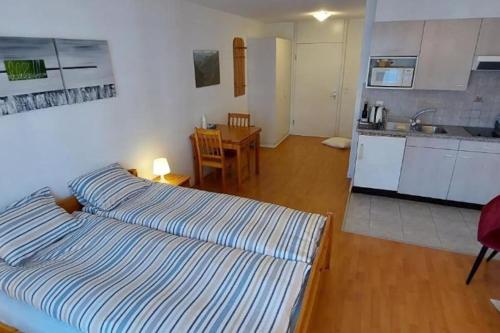 a bedroom with a bed and a kitchen with a table at Torgon Grand studio Confortable in Torgon
