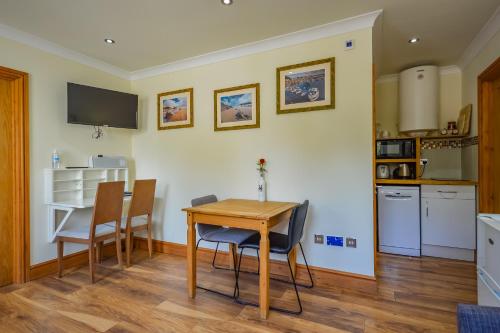 a kitchen and dining room with a table and chairs at Cosy Cabin Perfect To Explore in Garnant