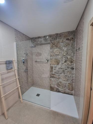 a shower with a glass door in a bathroom at Hortelã da Ribeira - Serra da Estrela in Cortes do Meio