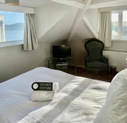 a bedroom with a bed with a dont disturb sign on it at Bella Vista in Llandudno