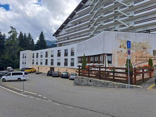 a large building with cars parked in a parking lot at Torgon Grand studio Confortable in Torgon