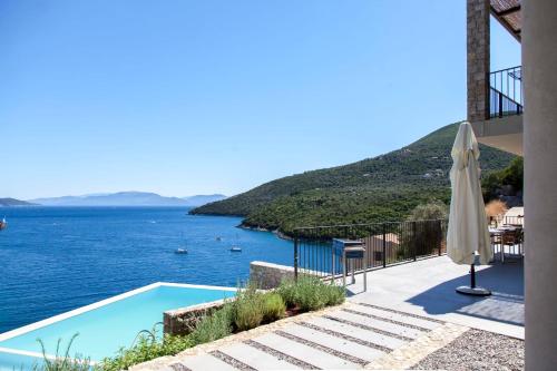 a villa with a pool and a view of the water at VILLAS MIRO - Luxury Villas with Direct Sea Access for 14 people in Sivota