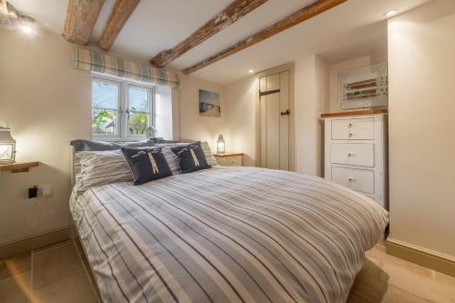 a bedroom with a bed and a window at Mayes Cottage in Brancaster