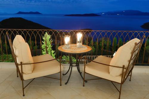 シヴォタにあるVilla Auriga - Spacious Villa with Magnificent Sea Viewのバルコニー(椅子2脚、キャンドル付きテーブル付)