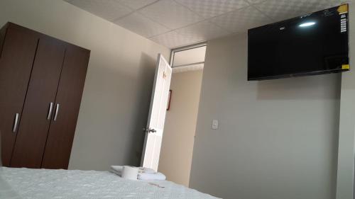 Pokój z łóżkiem i telewizorem z płaskim ekranem na ścianie w obiekcie HOSTAL IMPERIO KALLPA w mieście Chachapoyas