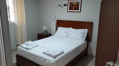 a bedroom with a bed with two towels on it at HOSTAL IMPERIO KALLPA in Chachapoyas