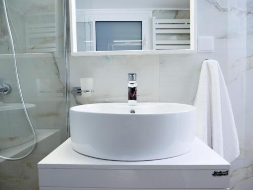 La salle de bains blanche est pourvue d'un lavabo et d'une douche. dans l'établissement Acropolis Apartment K, à Athènes