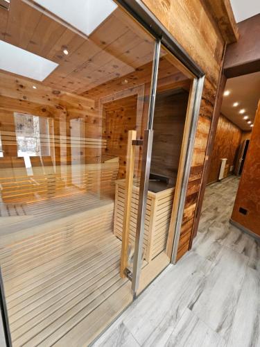 an empty sauna with wooden walls and wood flooring at Chalet La Rugiada in Bormio