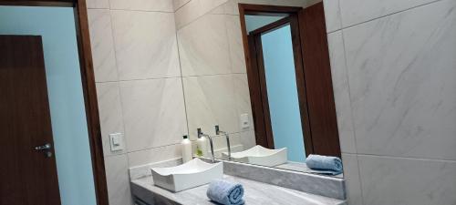 een badkamer met 2 wastafels en een grote spiegel bij Cafofo Prea in Cruz